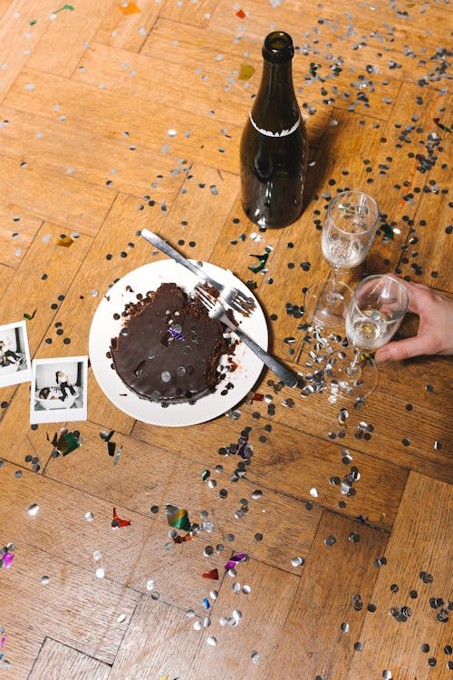 Person Holding Wine Glass on the Floor