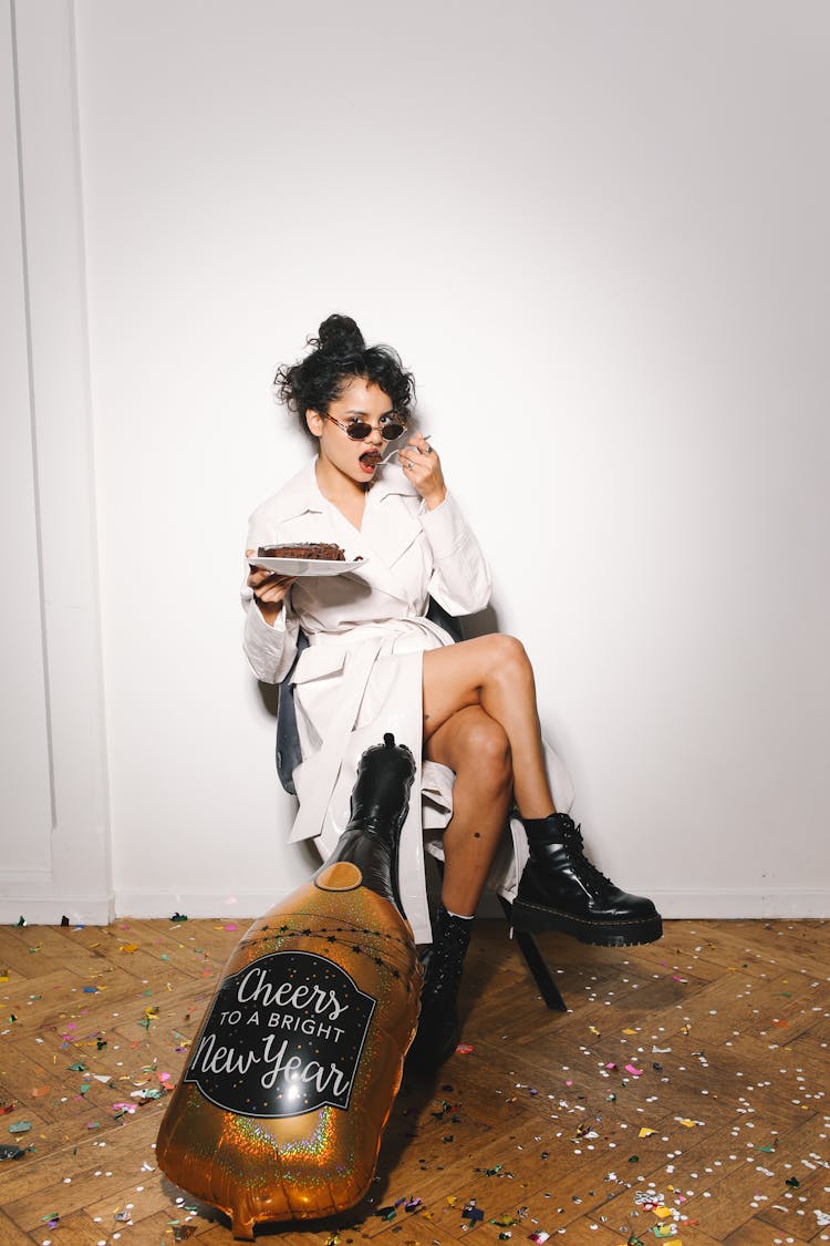 A Woman In White Trench Coat Eating Cake