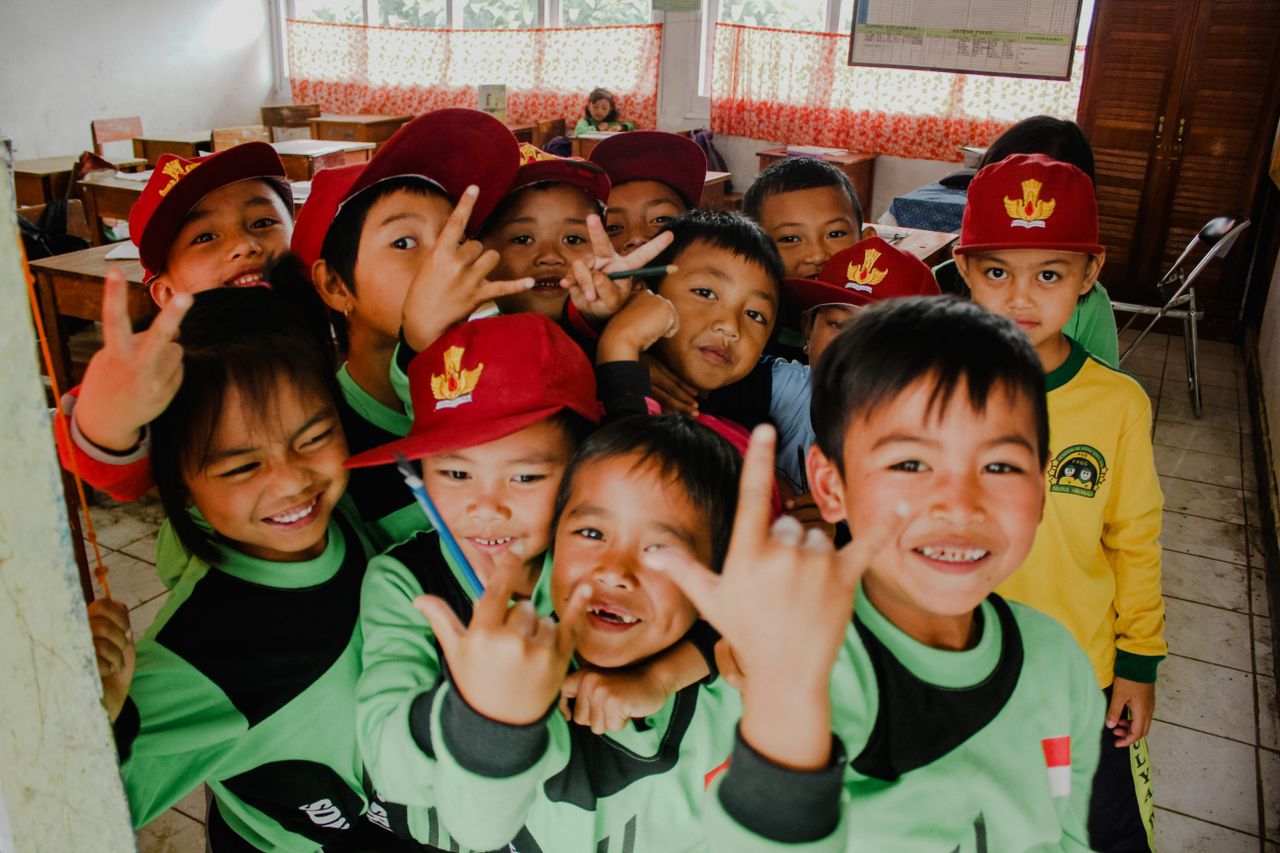 Sekelompok anak Indonesia tersenyum bersama di ruang kelas