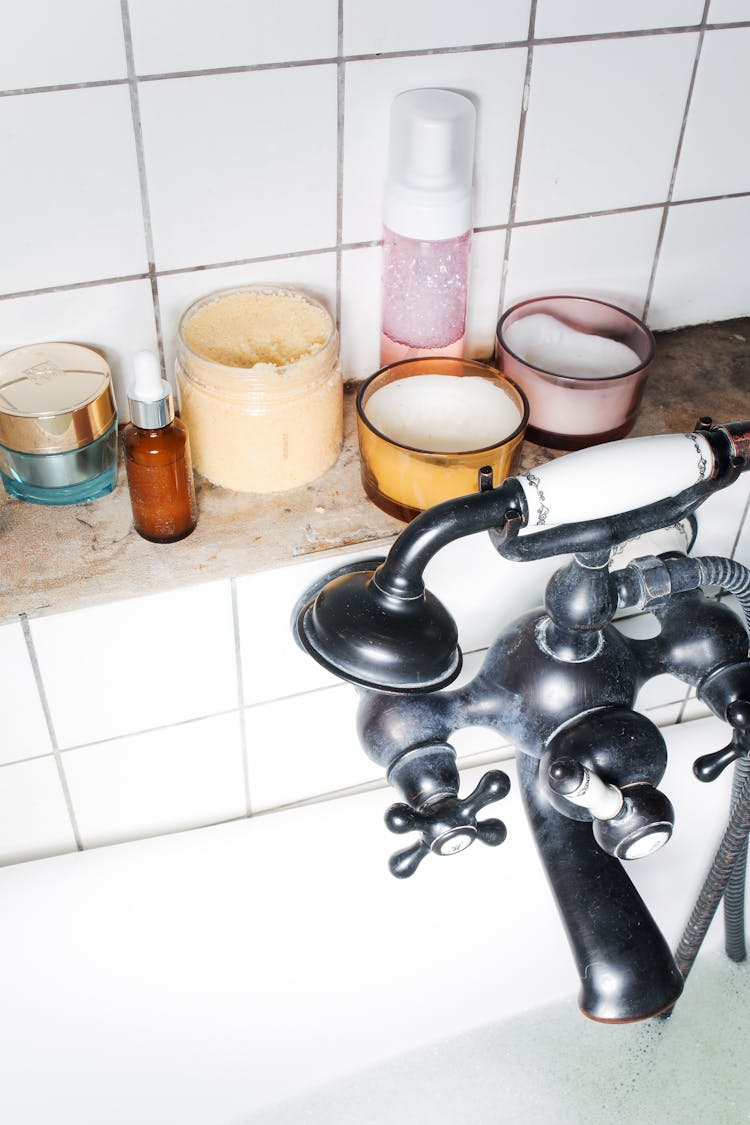 Bottles And Jars Of Skincare Products Near A Faucet