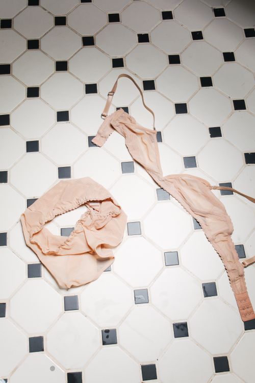 Free Beige underwear on a tiled bathroom floor adds a realistic touch to the scene. Stock Photo