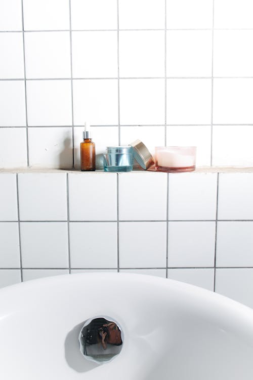 Skincare Products on a Ledge of a Tiled Wall