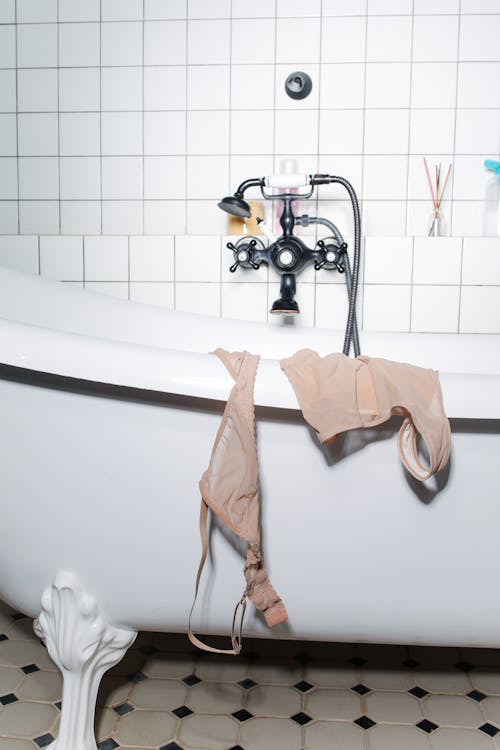 Free Woman's Underwear Hung on the Side of the Bathtub Stock Photo