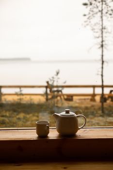 窗台上的茶壶和杯子静静俯瞰着户外的宁静景色