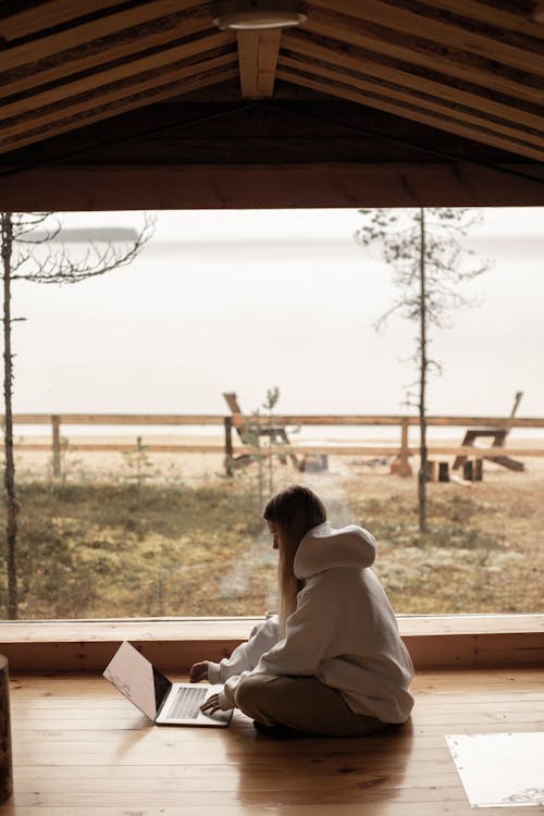 Woman Wearing a Hoodie Long Sleeve Sitting on Wooden Floor