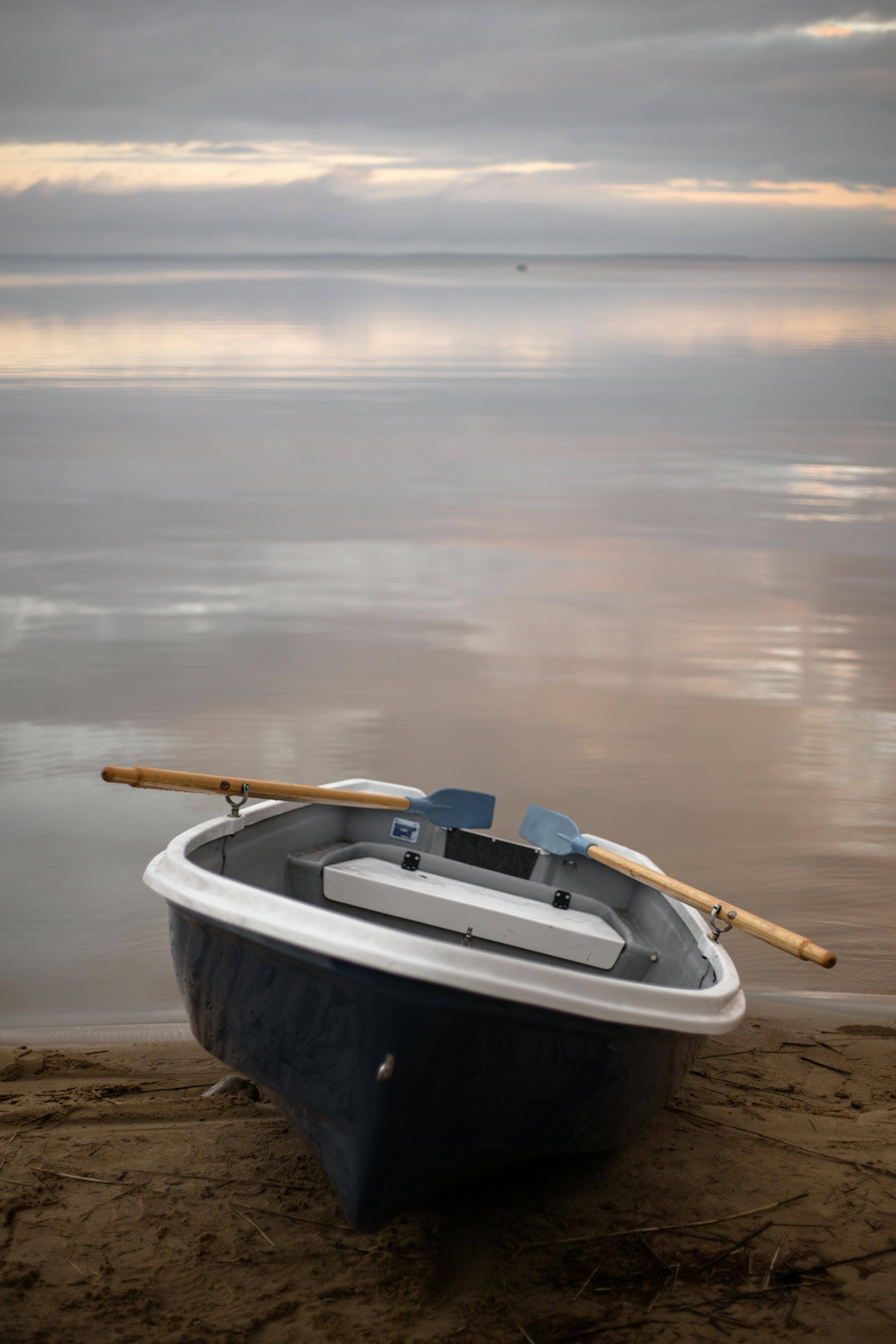 a boat on brown sand beside the body of water