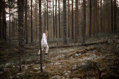 Woman in White Sweater Walking in the Woods

