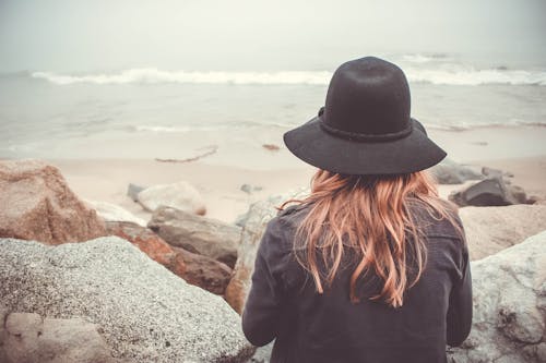 Free Person Sitting in Front of Rocks Stock Photo