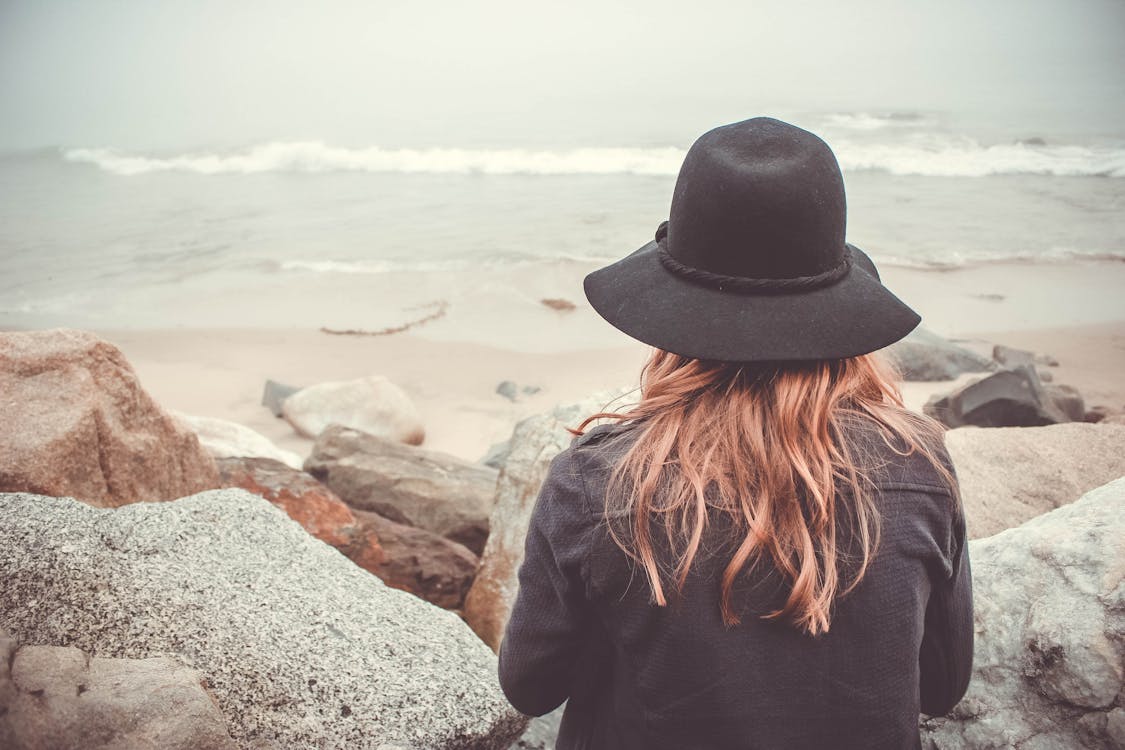 Person Sitting in Front of Rocks