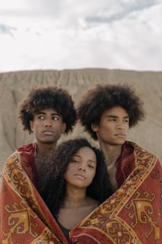 三个年轻人裹在充满活力的户外毯子里，散发着团结与风格