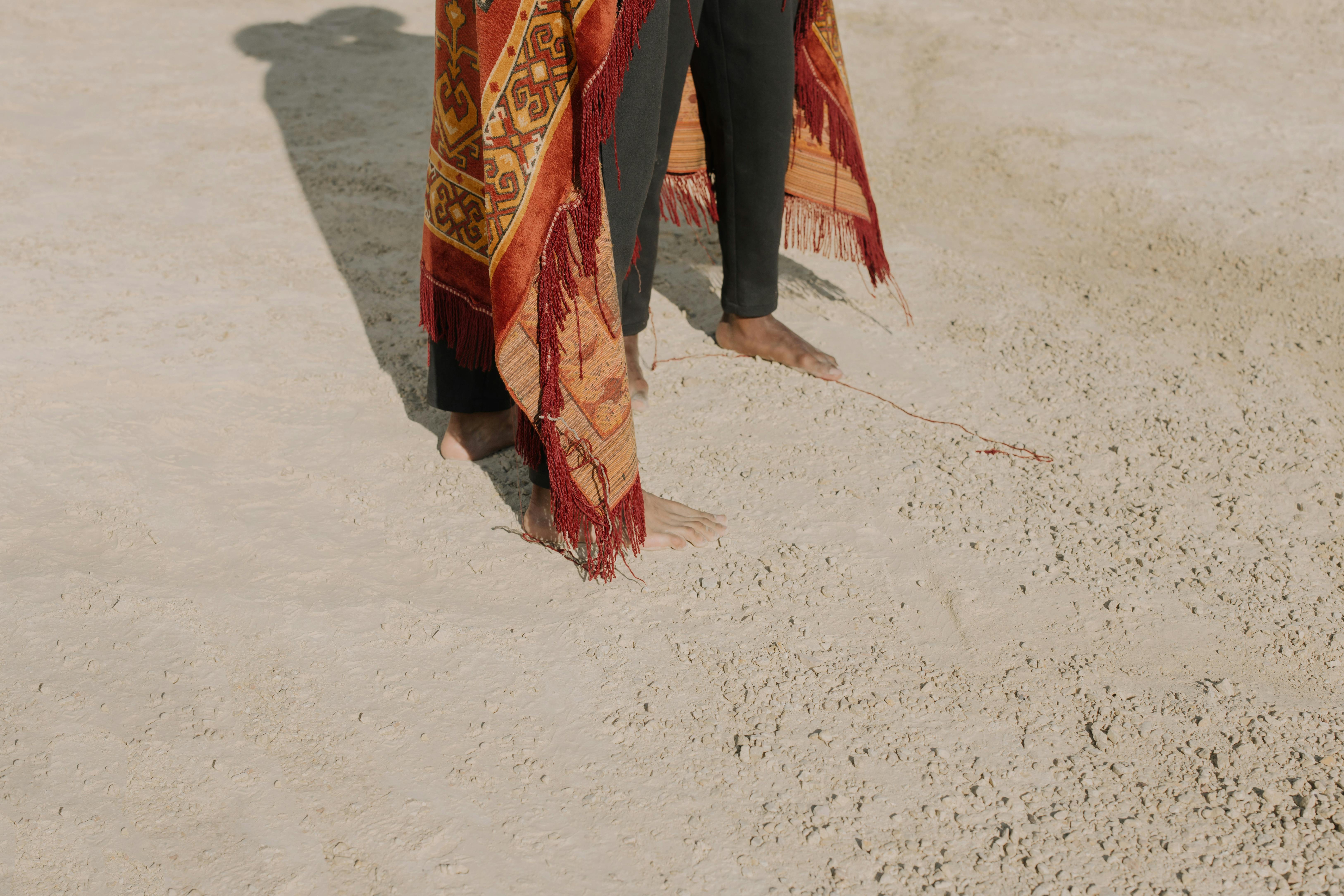 men s standing barefooted over white sands