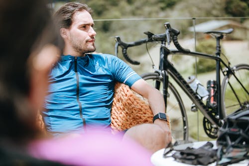 Atleta Masculino Contemplativo Cerca De Bicicleta Y Amigo Anónimo