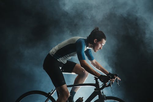 Free Determined bicyclist riding bike in overcast weather in evening Stock Photo