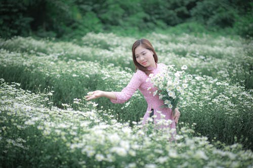 Woman in Pink Dress Picking White Flowers