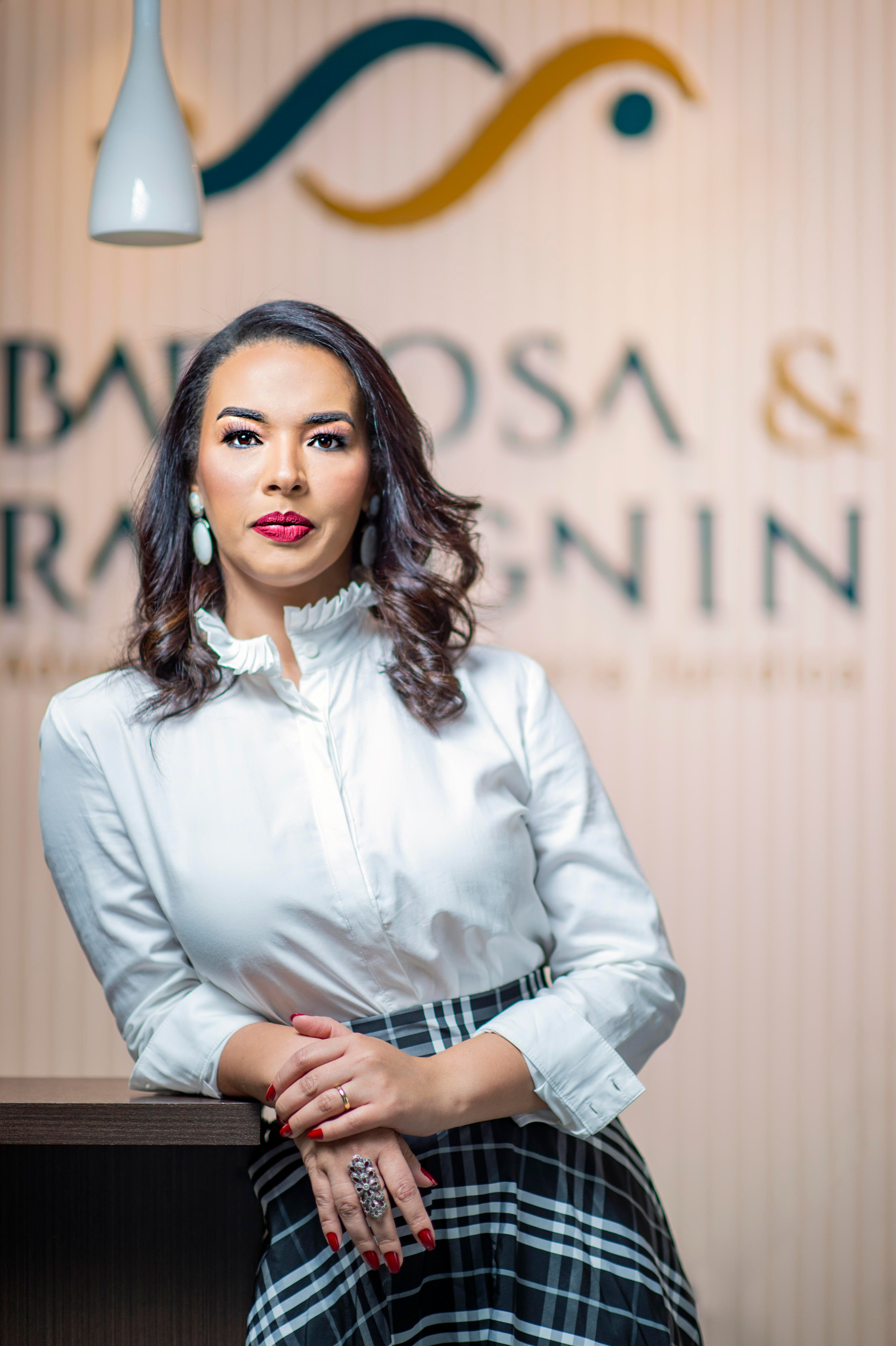 A professional woman in smart casual attire poses confidently indoors.