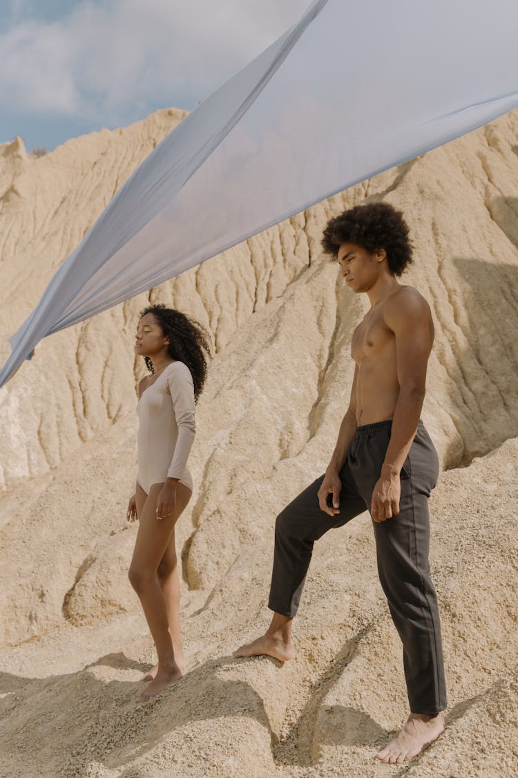 A Young Man And A Young Woman Standing On A Natural Rock Formation