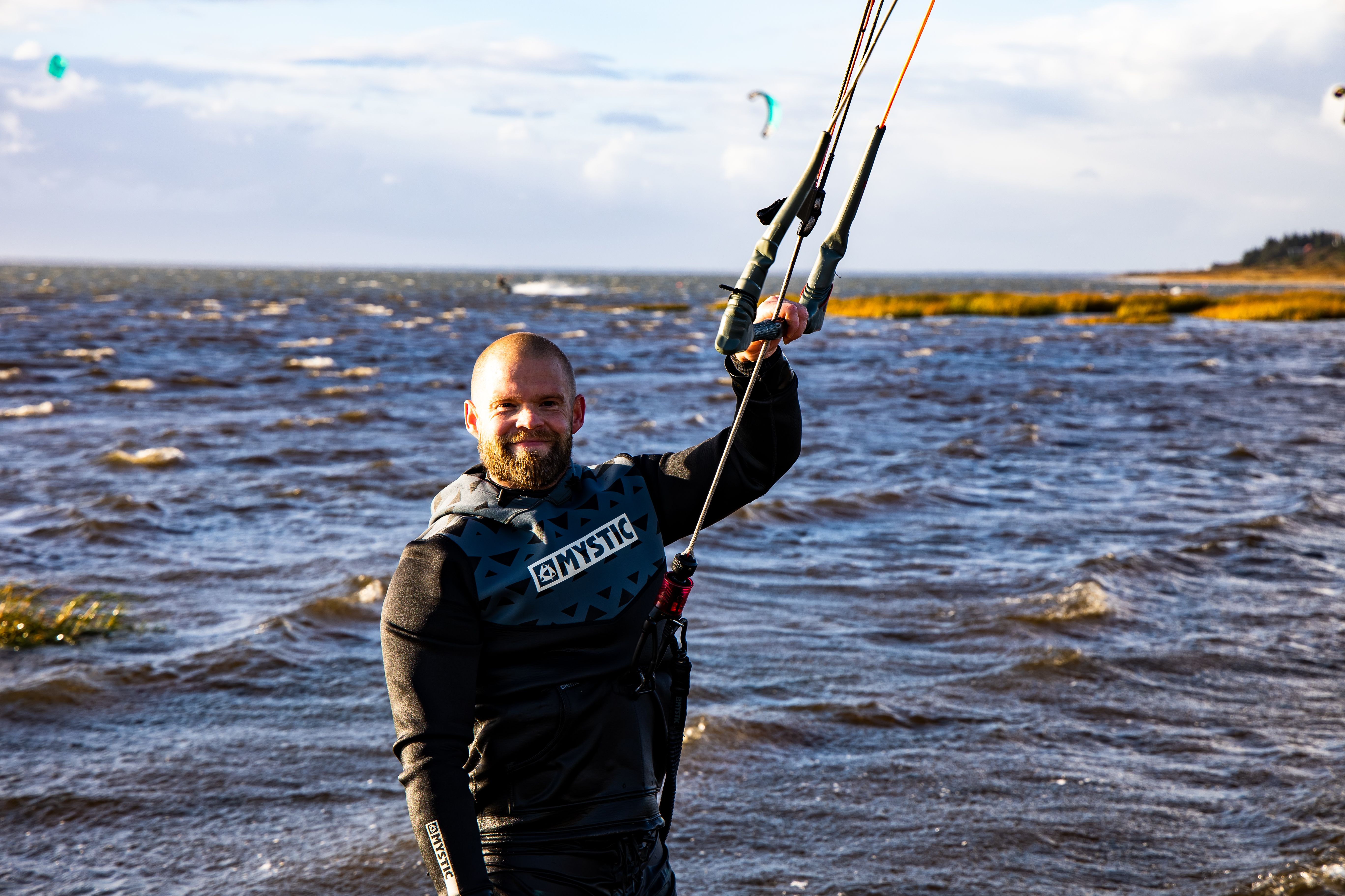 Smiling bearded man kitesurfing and enjoying an active lifestyle by the sea.