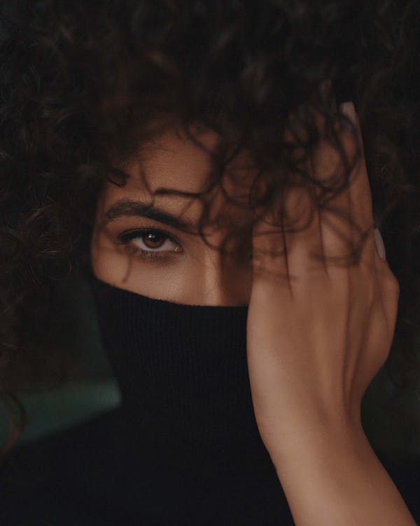 A Woman Covering Half of Her Face With Her Hand