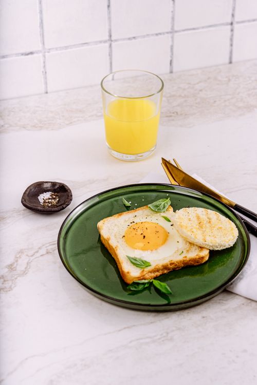 Free Enjoy a warm breakfast with sunny side up egg on toast and refreshing juice. Stock Photo