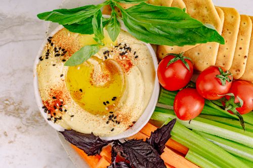 Free Top view of hummus with vegetables and crackers, perfect for healthy snacking. Stock Photo