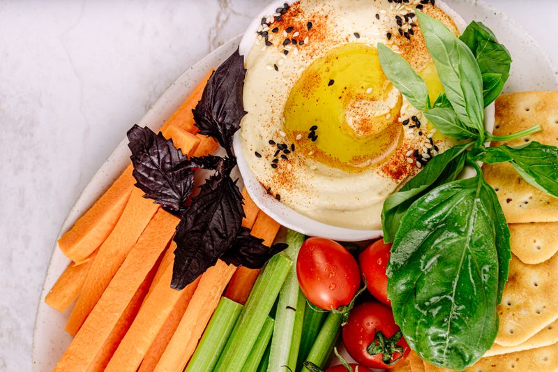 snack plate with hummus, carrots, and crackers