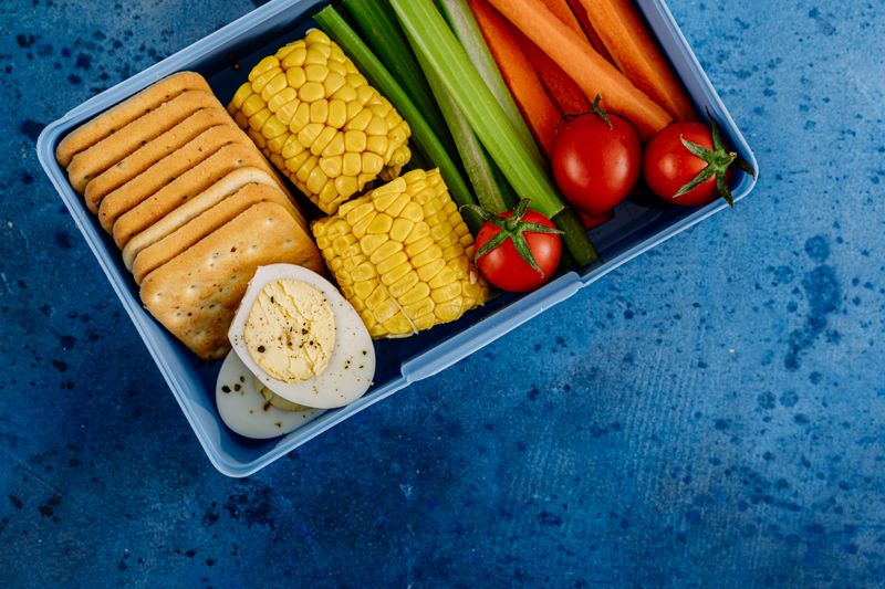 hummus with sliced vegetables in a bento box