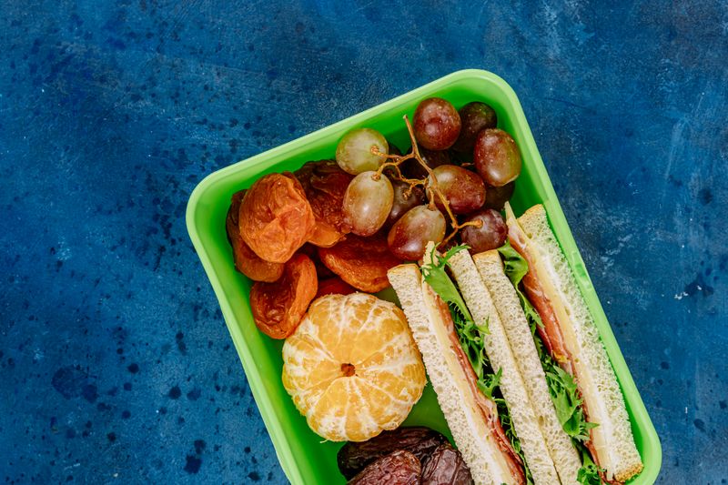 cheese, crackers, and grapes arranged in a lunch box