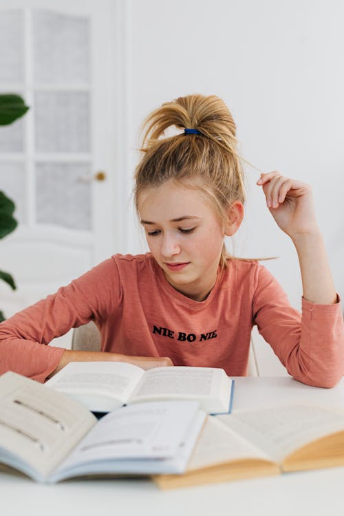 Girl in Long Sleeve Shirt Reading