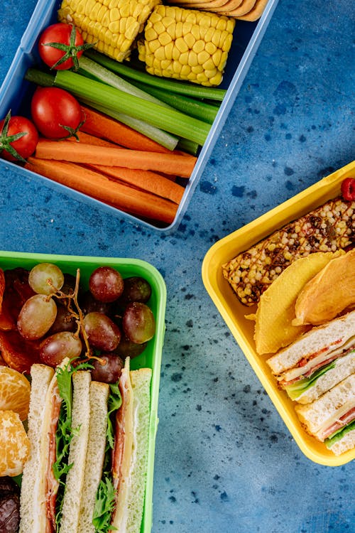 Photo of Lunch Boxes with Sandwiches and Vegetables