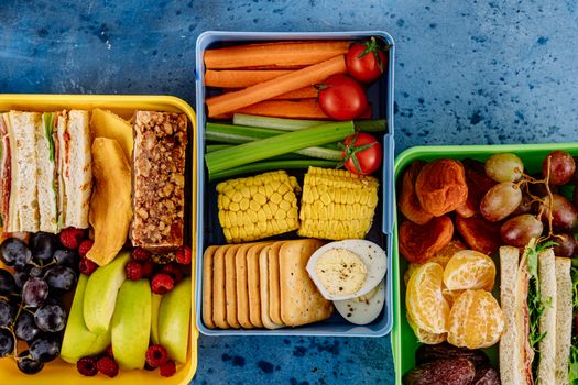 Vibrant assortment of sandwiches, fruits, and veggies in lunchboxes. Perfect for healthy meal prep inspiration.