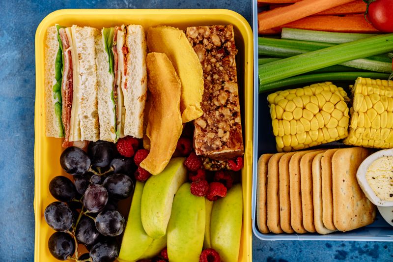 small containers filled with nuts, fruit, and crackers lined up
