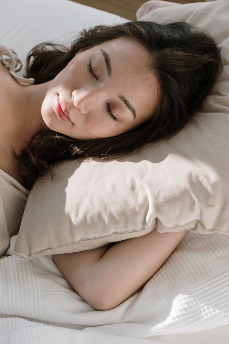 Woman Sleeping With Pillow On Bed