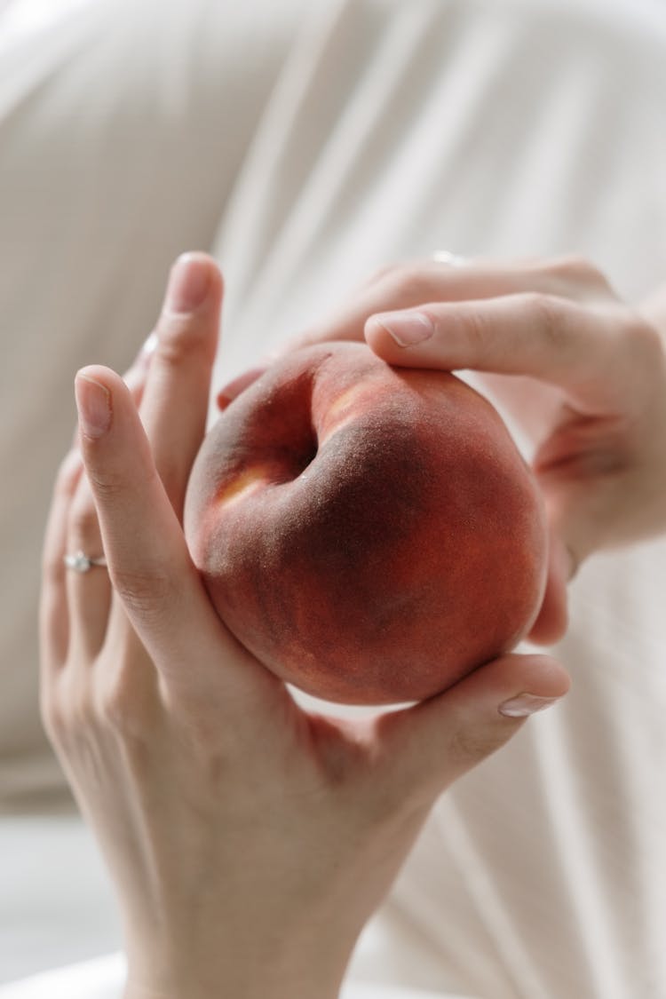 A Person Holding A Peach