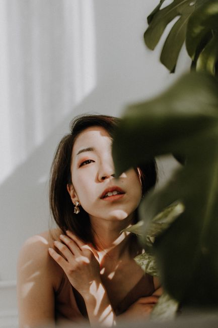 A captivating portrait of a woman with natural light and shadows creating an artistic effect.