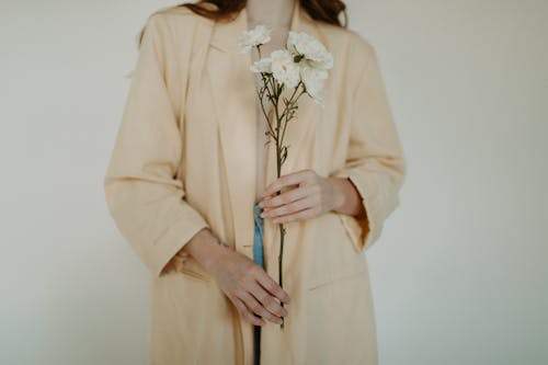 A Woman in Yellow Long Sleeves Holding White Flowers