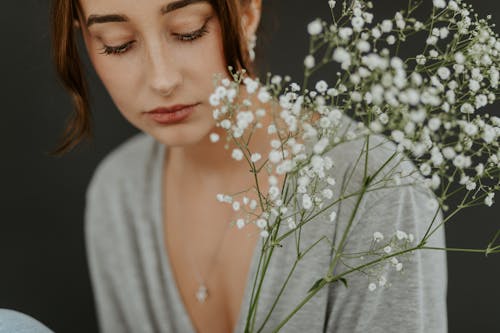 A Woman Near White Baby's Breath Flowers