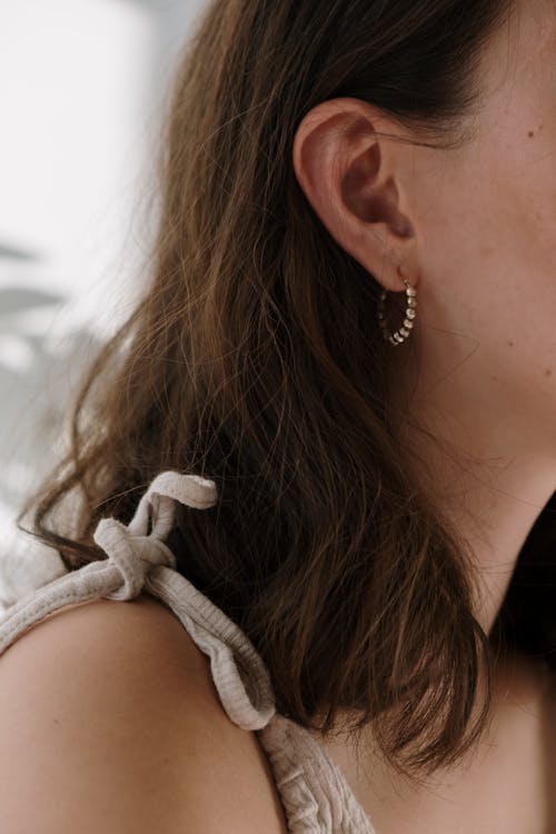 Close-Up Shot of a Brown-Haired Woman Wearing an Earring