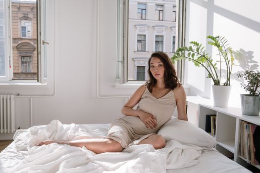 Woman in White Dress Sitting on Bed