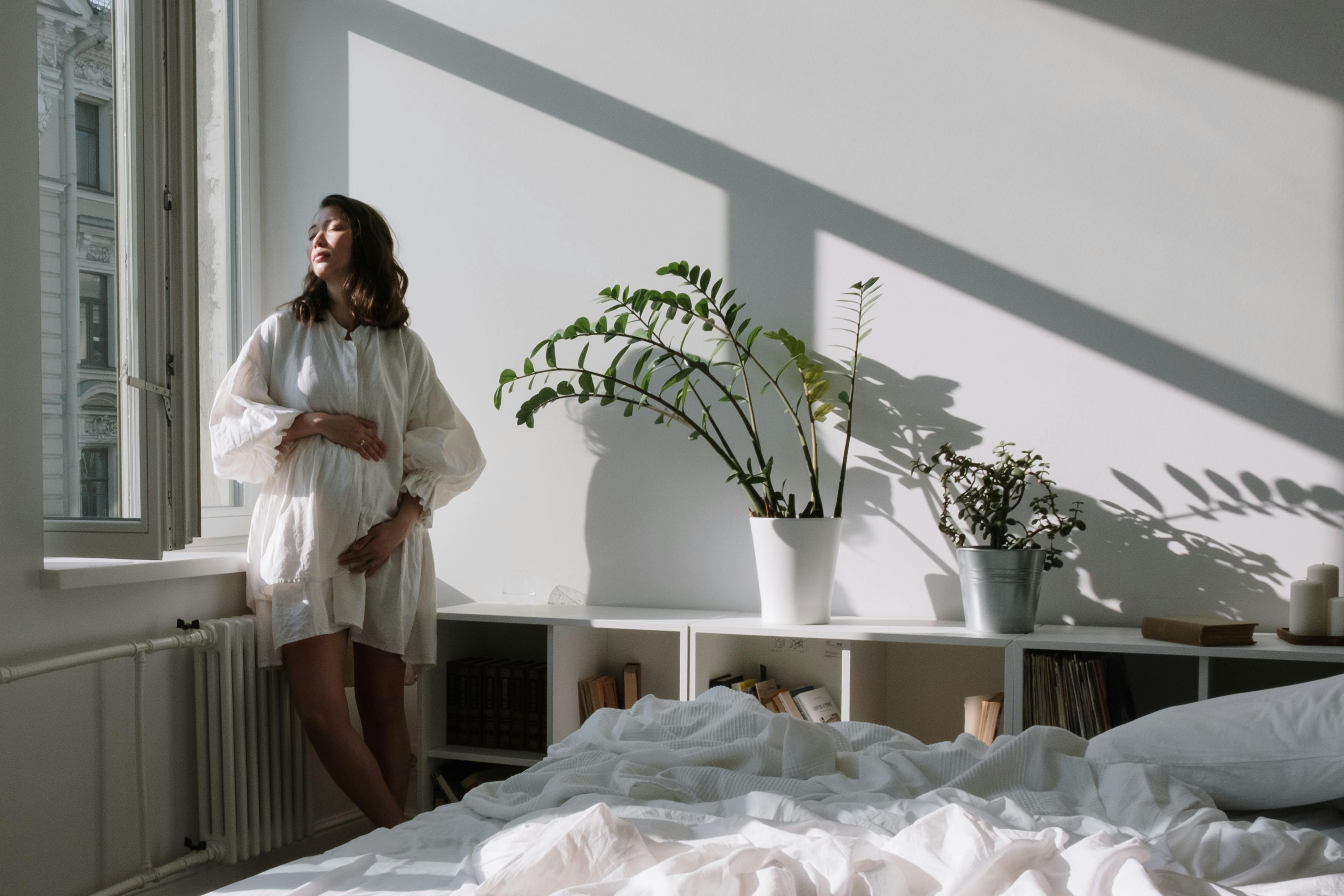 woman in white long sleeve shirt standing on bed