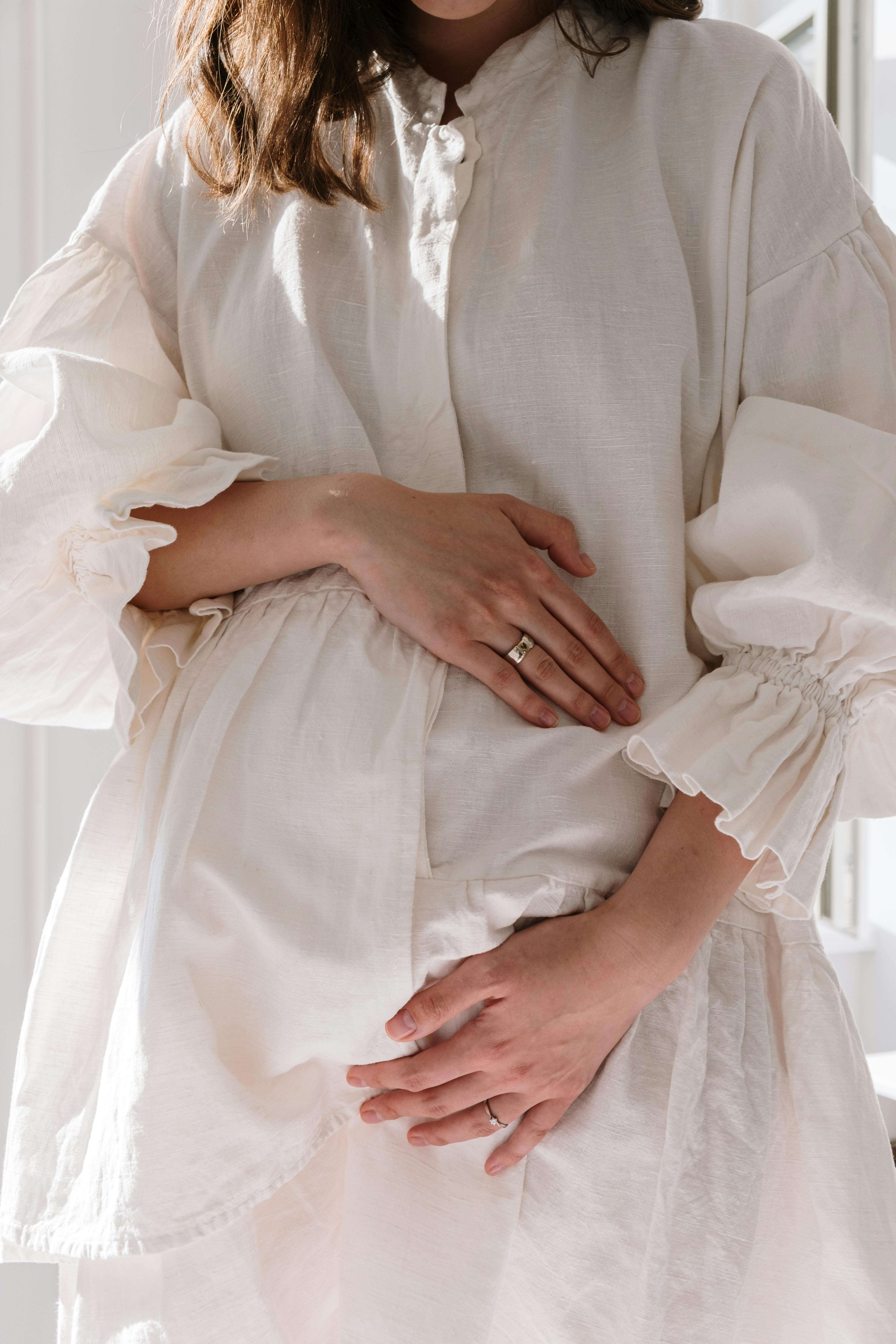 a pregnant woman in white dress