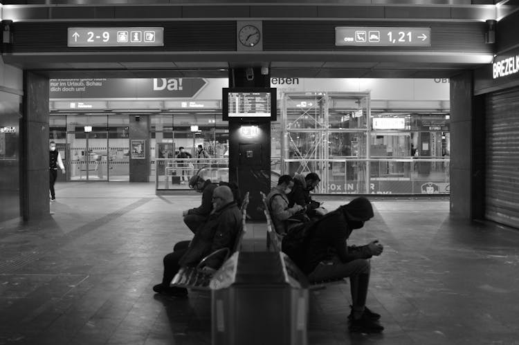 People Sitting On Benches Inside An Airport