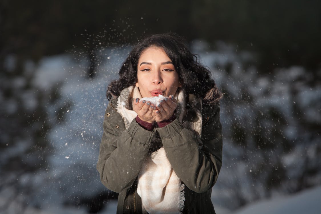 Woman Blowing Snow Outdoors