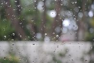 圣地亚哥，雨滴特写于窗户之上，户外景象模糊，营造出一种喜怒无常的抽象感