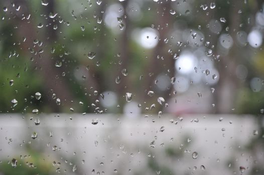 圣地亚哥，雨滴特写于窗户之上，户外景象模糊，营造出一种喜怒无常的抽象感