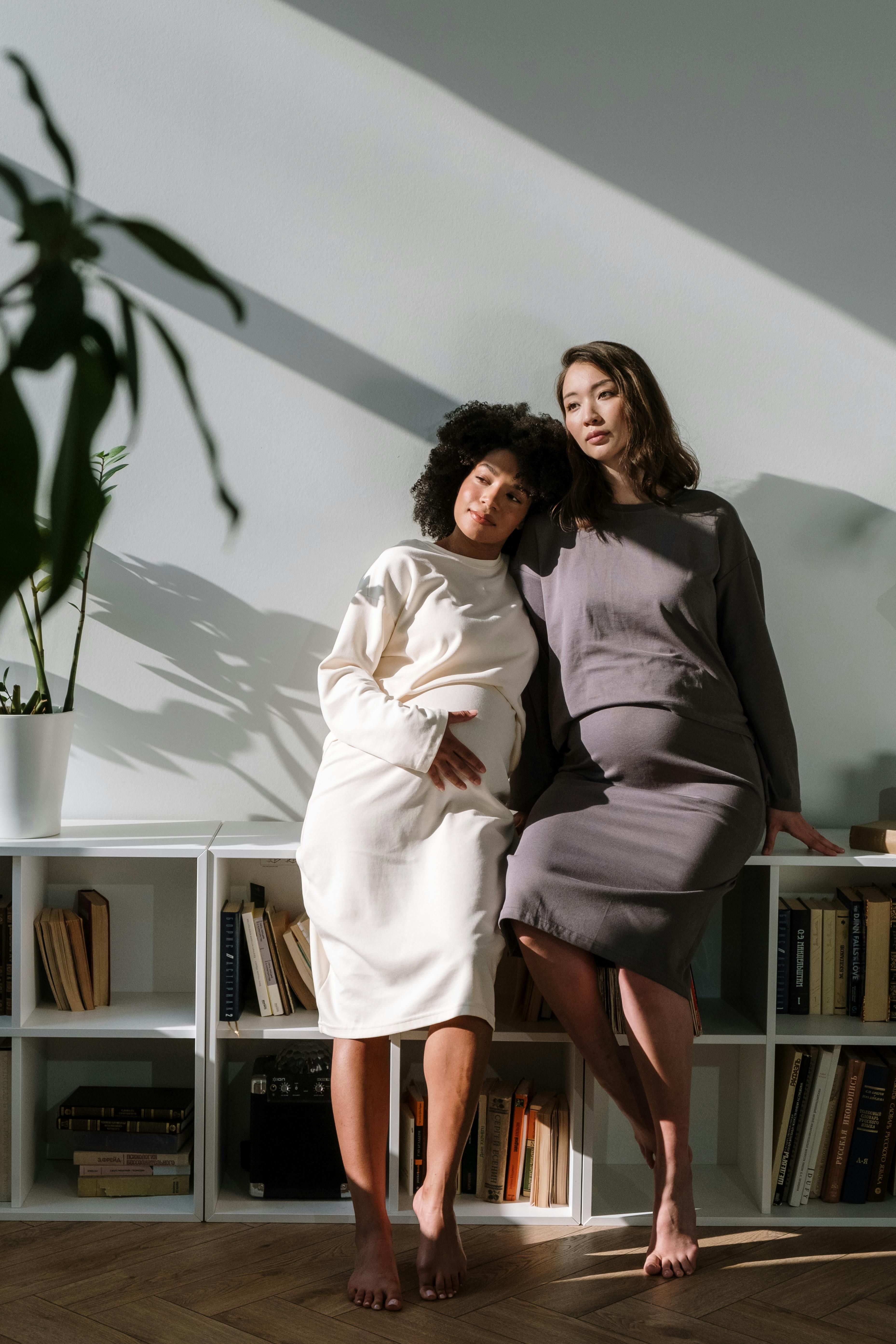 2 women sitting on brown wooden chair