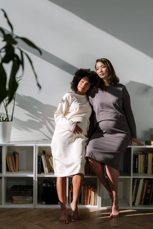 2 Women Sitting on Brown Wooden Chair