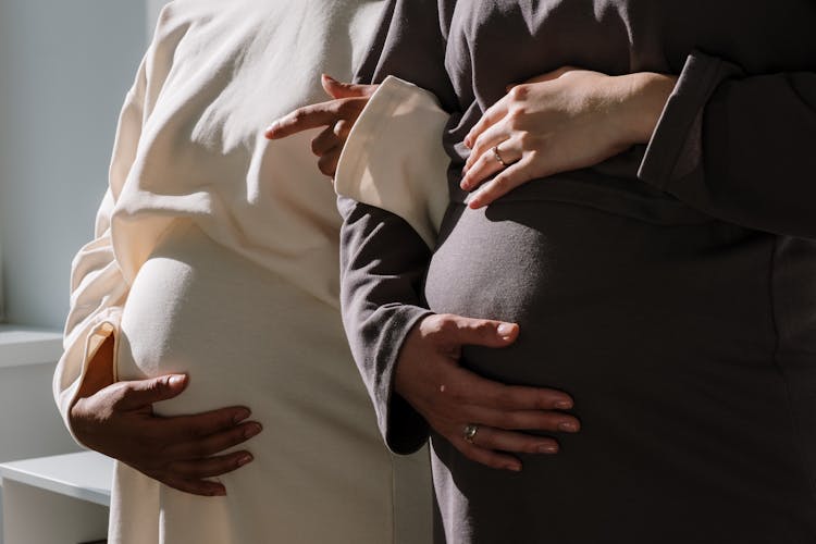 2 Pregnant Woman In Long Sleeve Dresses