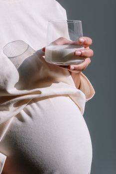 特写镜头中，孕妇手持一杯牛奶，象征着养育与护理