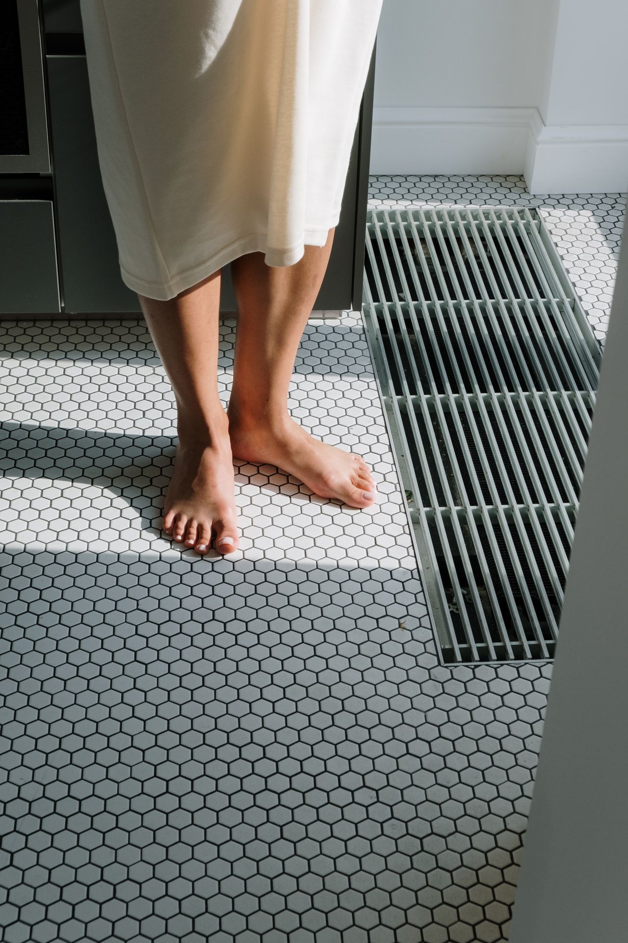 Kobieta boso na ogrzewanej podłodze ceramicznej — ogrzewanie podłogowe pod płytkami, LOFTBAU Kraków