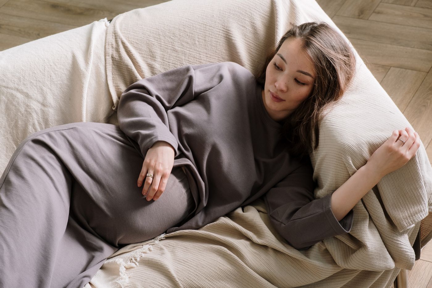 Femme enceinte se reposant sur un canapé pour améliorer le confort de son dos